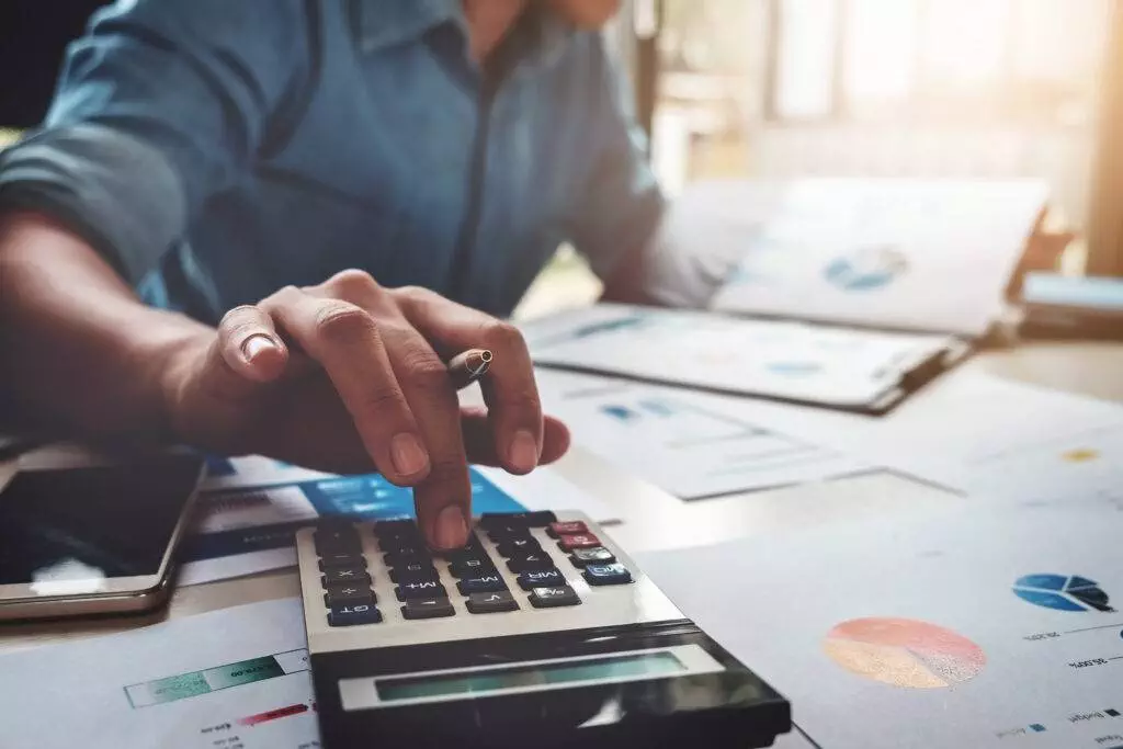 Business man using calculator with