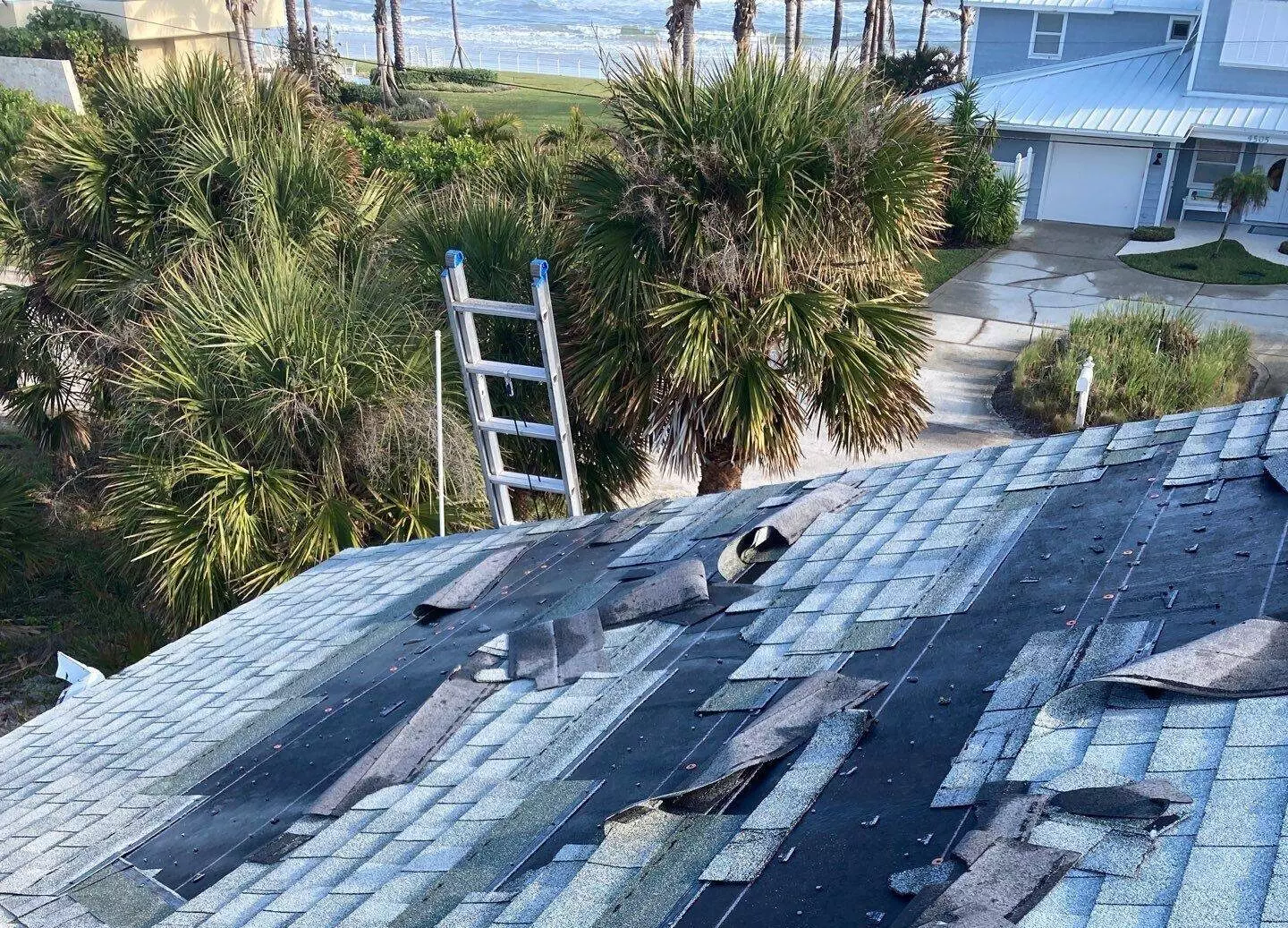 damage to shingle roof from high wind in Florida on home by the ocean